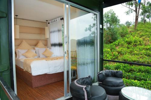 a room with a bed and a balcony with a view at Box on clouds in Ella