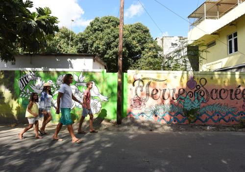 a group of people walking in front of a wall with graffiti at Veranda Tamarin Hotel & Spa in Tamarin