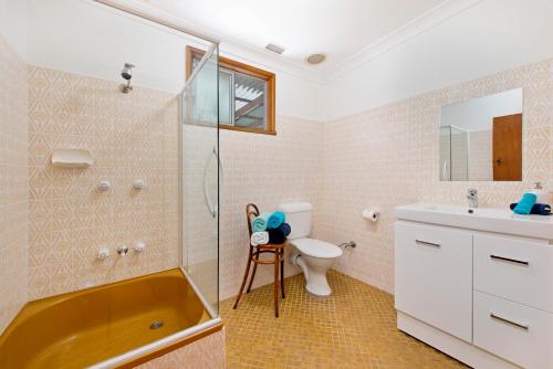 a bathroom with a tub and a toilet and a sink at Salt Breeze in Lake Cathie
