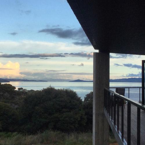 a view of the ocean from a balcony of a house at La Bodega Waiheke Island in Surfdale