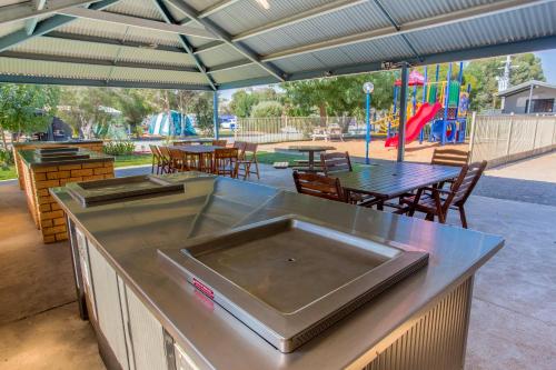 a kitchen area with a table and chairs at BIG4 Shepparton Park Lane Holiday Park in Shepparton