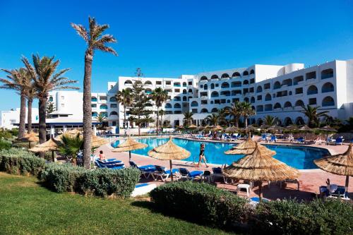 a resort with a large swimming pool with umbrellas at Regency Hotel & Spa in Monastir