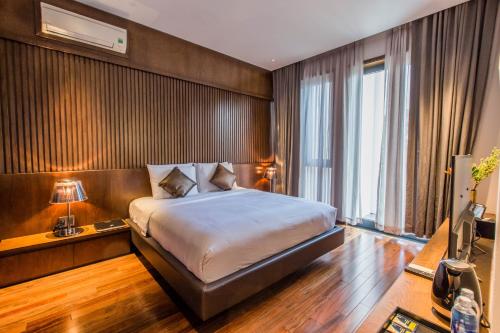 een slaapkamer met een bed en een groot raam bij Icity Villa Riverfront Danang in Da Nang