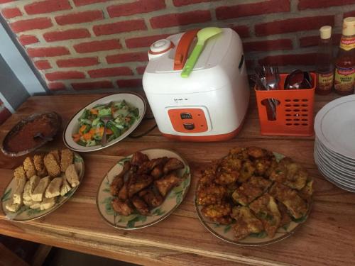 a table with plates of food and a toaster at Homestay Lereng Bromo in Bromo