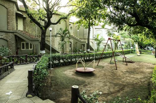 a playground with a swing set in a yard at Ras Resort By Treat Silvassa in Silvassa
