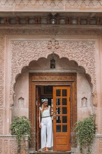 a woman standing in the doorway of a building at Alsisar Haveli - Heritage Hotel in Jaipur