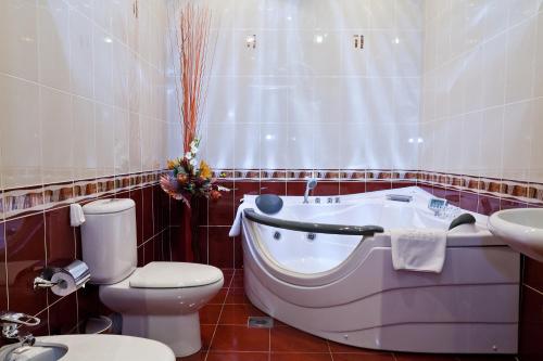 a bathroom with a tub and a toilet and a sink at Richmond Hotel in Yekaterinburg