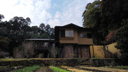 a house on a hill with a stone wall at 森と空と家 Spacious private house Moritosora in Sammu