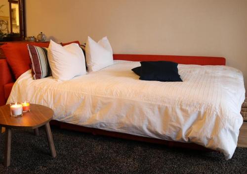 a bed with white sheets and pillows and a table at De Villo in Hasselt