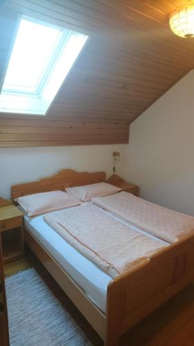 Bett in einem Zimmer mit Fenster in der Unterkunft Farm Stay Ramšak in Zreče