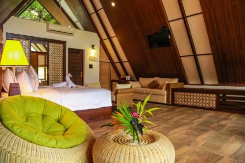 a room with a bedroom with a bed and a chair at Liyya Water Villas in Dambulla