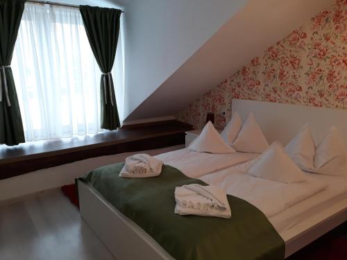 a bedroom with a bed with two towels on it at Pensiunea Casa Rusu in Baia Mare