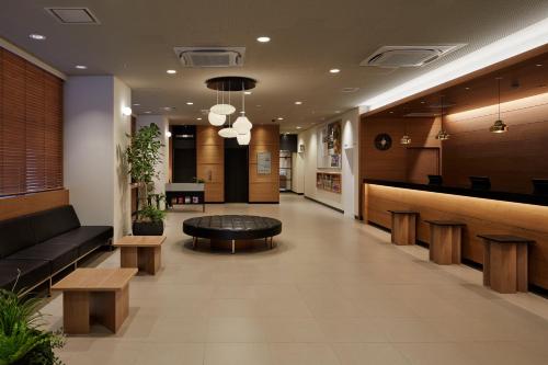 a lobby of a hospital with a table and benches at Nishitetsu Inn Nihonbashi in Tokyo
