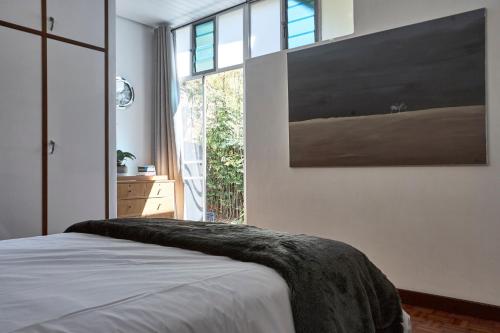 a bedroom with a bed and a large window at House Sandrock Muckleneuk Selfcatering apartment in Pretoria