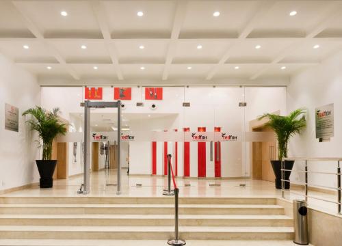 a lobby with stairs and flags in a building at Red Fox by Lemon Tree Hotels, Dehradun in Dehradun