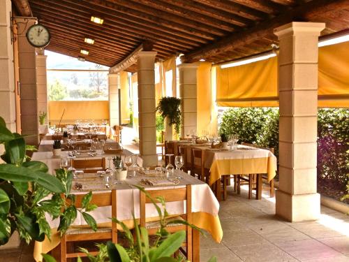 a restaurant with tables and a clock on the wall at Albergo Isetta in Grancona