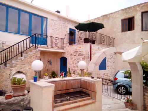 een huis met een trap en een paraplu bij Arches Eleftherna in Elefterna