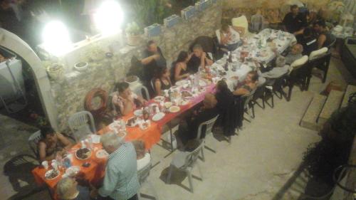 een groep mensen die aan een lange tafel zitten bij Arches Eleftherna in Elefterna