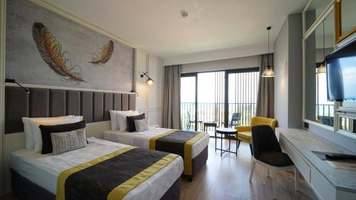 a hotel room with two beds and a desk at The Raga Side Ultra All Inclusive in Side