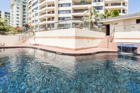 Cairns Apartment Esplanade Ocean Views في كيرنز: تجمع كبير للمياه امام مبنى