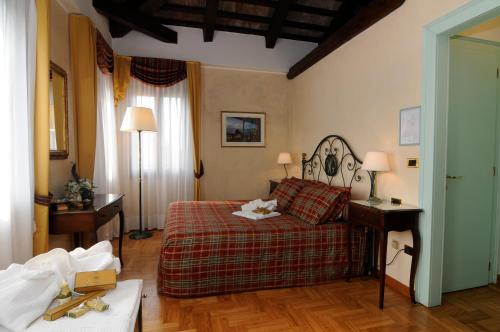 een slaapkamer met een bed, een tafel en lampen bij Villa Goetzen in Dolo