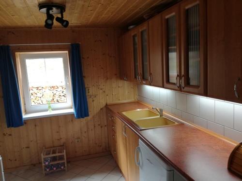 a kitchen with a sink and a window at Chata Brigit in Vrbno pod Pradědem