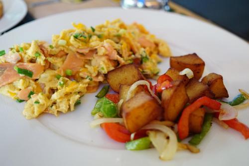 a plate of food with scrambled eggs and potatoes at Metro Apartments in Pattaya Central