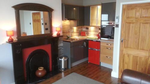 a kitchen with a fireplace in the middle of a room at Apartment Chic in Barmouth