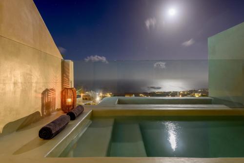 a house with a swimming pool at night at Divelia East in Imerovigli