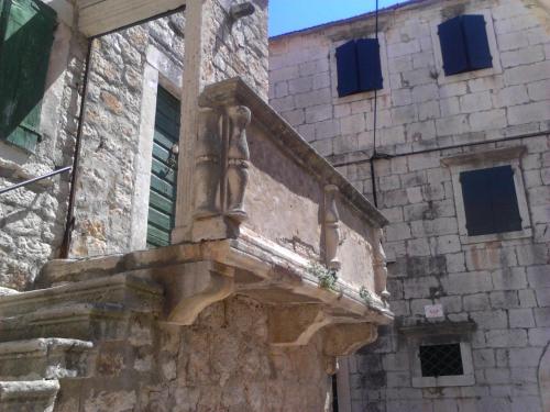 a stone building with a statue on the side of it at Apartments and Rooms Dobrila in Jelsa