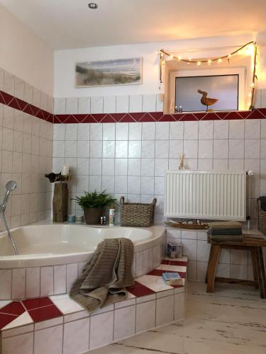 a bathroom with a bath tub and a table at Ankerplatz Güby in Güby