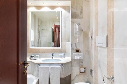 a bathroom with a sink and a toilet and a mirror at Hotel Internazionale in Bologna