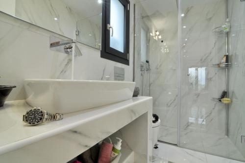 a white bathroom with a sink and a shower at Villa Larna Corfu in Kavvadádes