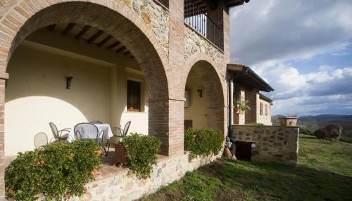 an outdoor patio with tables and chairs in a building at Collepetrucci in Ciciano