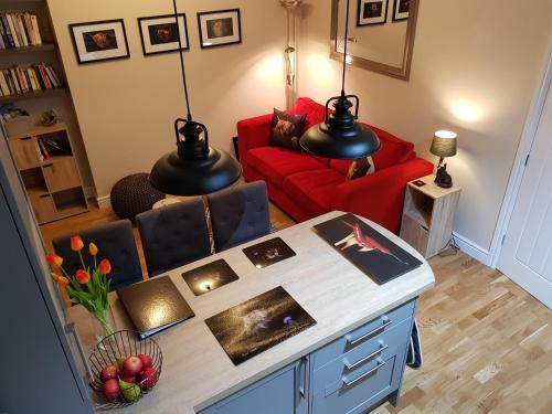 a living room with a red couch and a table at Smart & Cozy Holiday Apartment in the city centre in Inverness