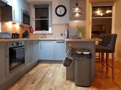 a kitchen with blue cabinets and a counter top at Smart & Cozy Holiday Apartment in the city centre in Inverness