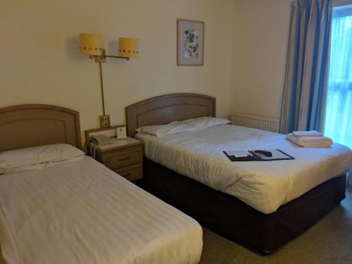 a hotel room with two beds and a window at Best Western Ipswich Hotel in Ipswich