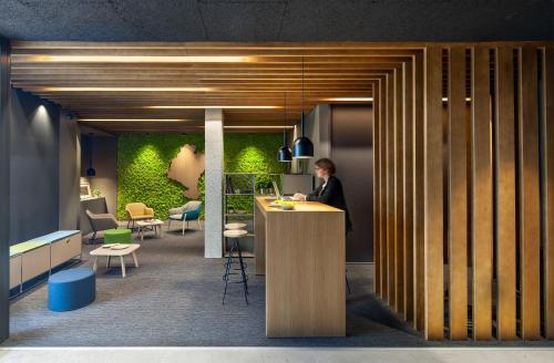 a woman sitting at a counter in an office with a laptop at ibis Styles Pamplona Noain in Noáin