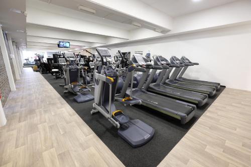 a gym with rows of treadmills and machines at City Hotel Krško in Krško