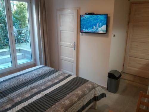 sypialnia z łóżkiem i telewizorem na ścianie w obiekcie Castle Base w Budapeszcie