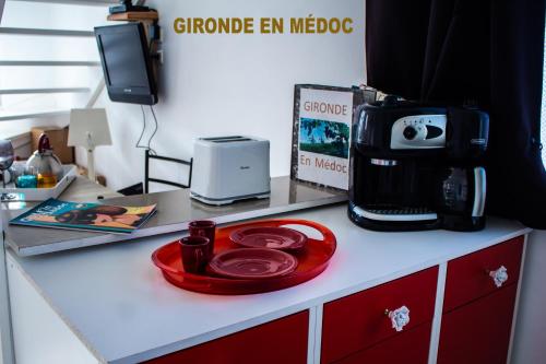 a kitchen counter with a coffee maker and a microwave at BUREAUX Appartements LESPARRE MEDOC in Lesparre-Médoc
