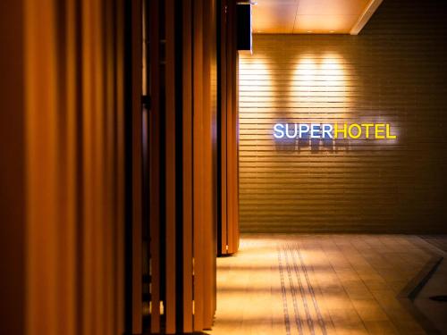 a sign that says super hotel on a garage door at Super Hotel Yamagata Sakurambo-Higashine Station Front in Higashine