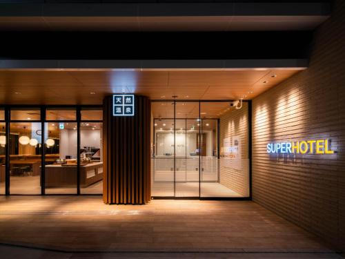 an entrance to a hotel with a sign on the door at Super Hotel Yamagata Sakurambo-Higashine Station Front in Higashine