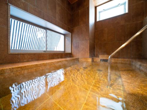 a room with a pool of water on the floor at Super Hotel Yamagata Sakurambo-Higashine Station Front in Higashine