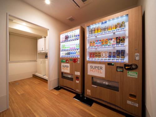 a vending machine with a super hotel sign on it at Super Hotel Yamagata Sakurambo-Higashine Station Front in Higashine