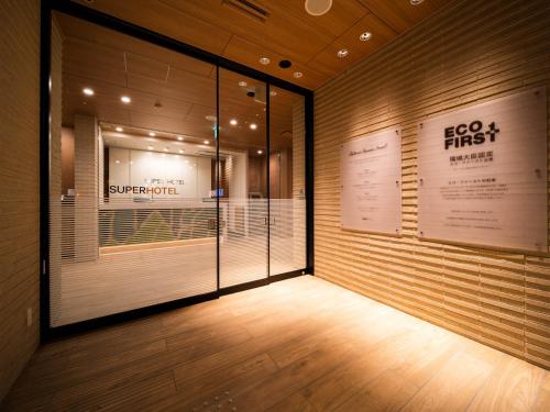 a store hallway with a large glass door and a sign at Super Hotel Yamagata Sakurambo-Higashine Station Front in Higashine