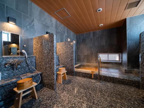 uma casa de banho com uma banheira e um lavatório em Super Hotel Yamagata Sakurambo-Higashine Station Front em Higashine