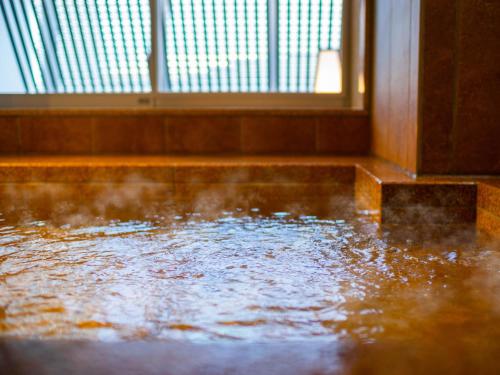 a pool of water in a room with a window at Super Hotel Yamagata Sakurambo-Higashine Station Front in Higashine