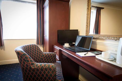 a room with a desk with a laptop and a chair at Roselawn Hotel in Reading