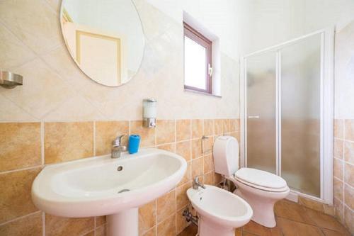 a bathroom with a sink and a toilet and a mirror at Bellavista in Acireale